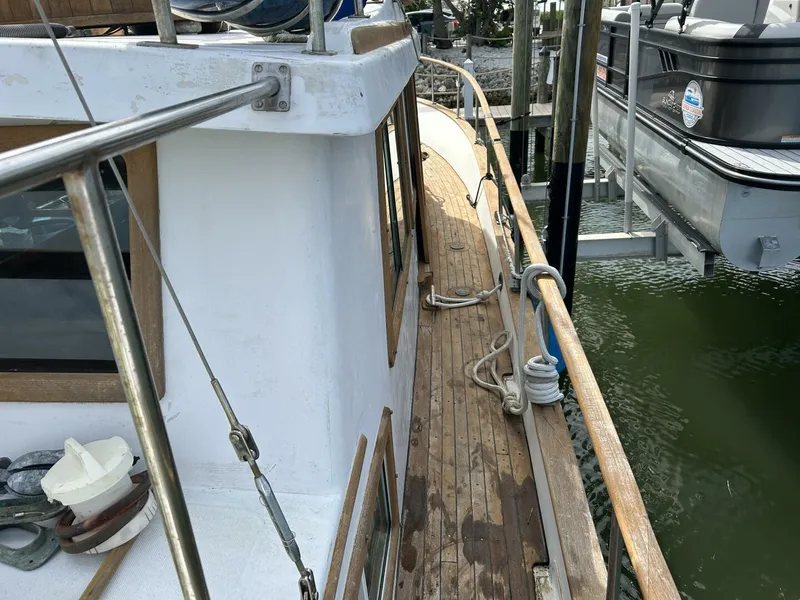 Slide: The Image of 1978 Albin 36 Trawler docked, showcasing wooden deck and railing details. - 45