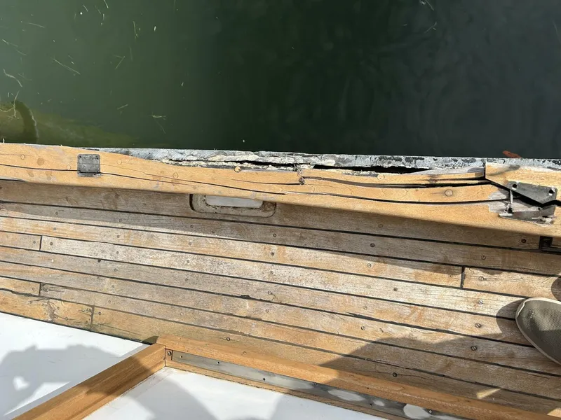 Slide: The Image of Wooden deck of a 1978 Albin 36 Trawler, showing wear and water proximity. - 46