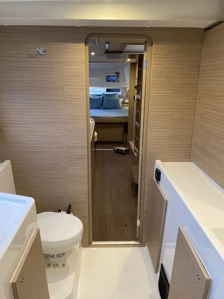 Slide: The Image of Interior of 2024 Lagoon 42 catamaran, featuring a modern bathroom and cozy bedroom. - 13