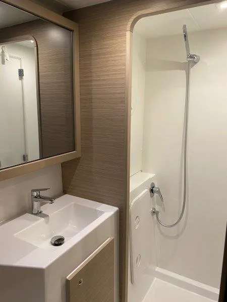 Slide: The Image of Modern bathroom in 2024 Lagoon 42 yacht with sink, mirror, and shower. - 15