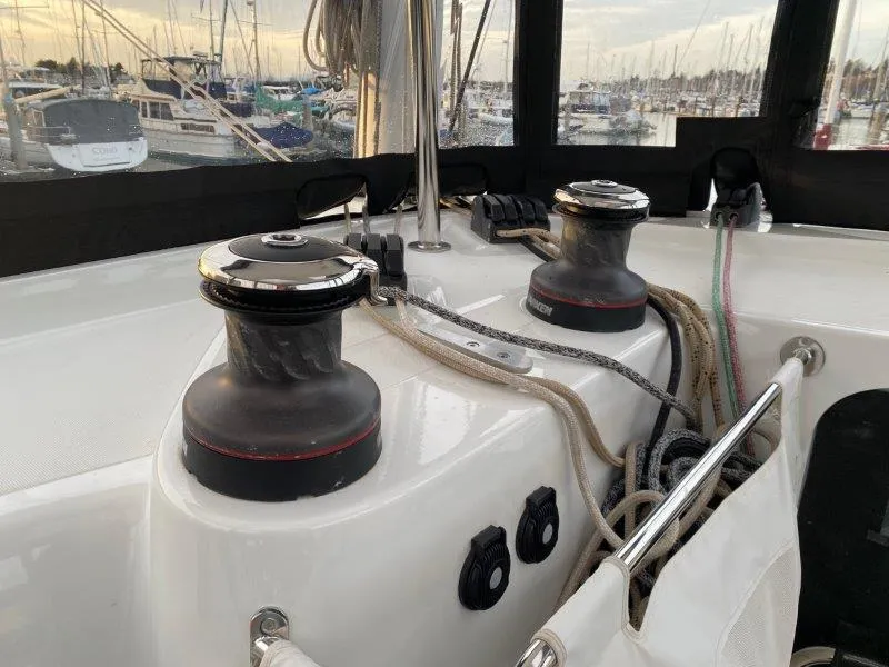 Slide: The Image of Lagoon 42 sailboat deck with winches and ropes, docked at marina, 2024 model. - 27