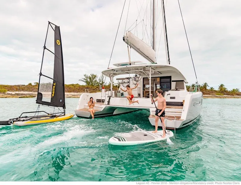 Slide: The Image of 2024 Lagoon 42 catamaran with people enjoying water activities. - 38
