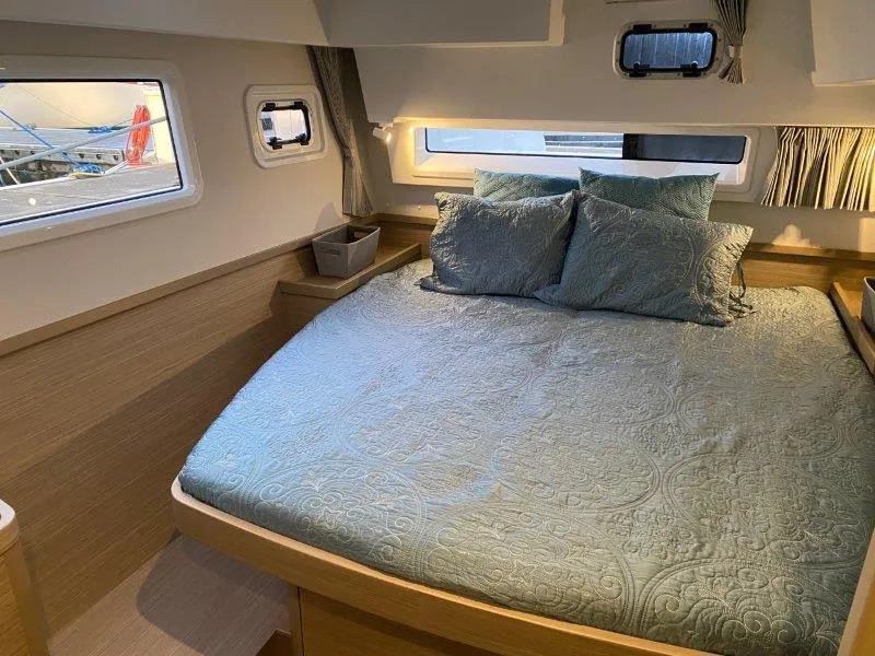 Slide: The Image of 2024 Lagoon 42 catamaran bedroom with double bed, windows, and modern decor. - 7