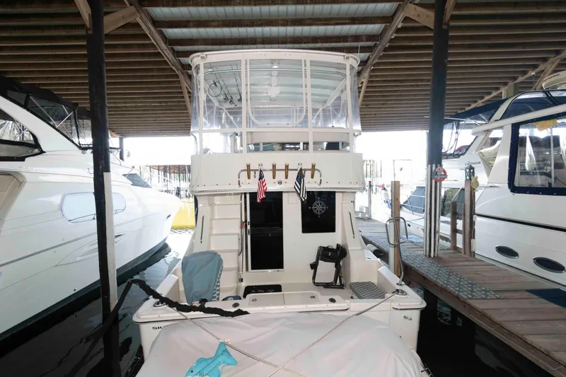 Slide: The Image of 2005 Silverton 34 Convertible yacht docked in a marina under a covered structure. - 2