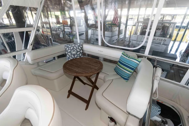 Slide: The Image of Interior of 2005 Silverton 34 Convertible yacht with cushioned seating and wooden table. - 8
