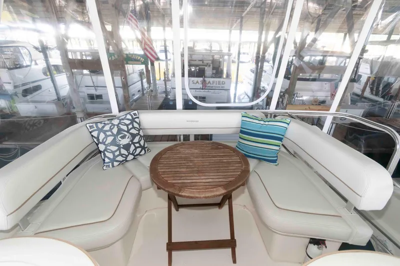 Slide: The Image of Interior of 2005 Silverton 34 Convertible yacht with cushioned seating and wooden table. - 9