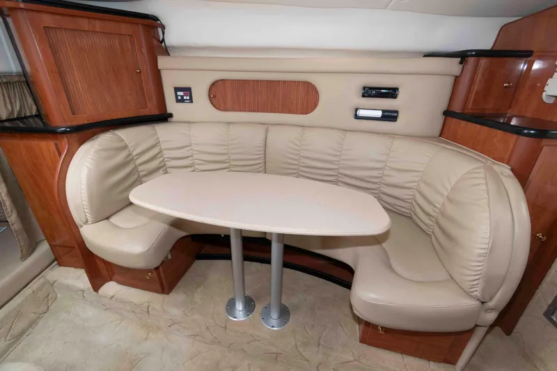 Slide: The Image of 2004 Rinker Fiesta Vee 342 interior with beige leather seating and wooden cabinetry. - 11