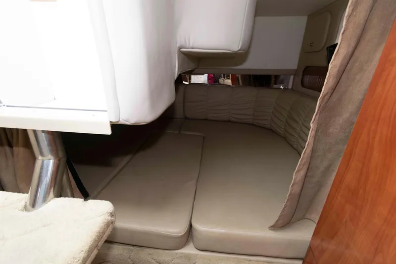 Slide: The Image of 2004 Rinker Fiesta Vee 342 cabin interior with beige seating and wooden accents. - 14