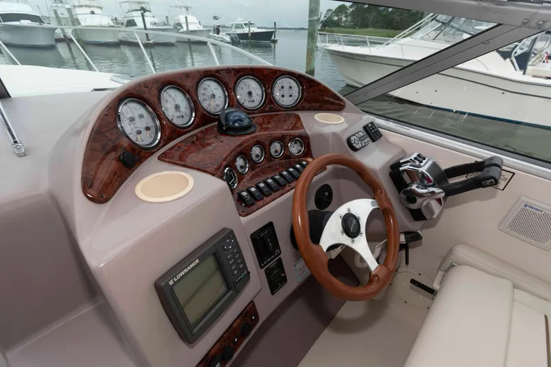 Slide: The Image of 2004 Rinker Fiesta Vee 342 boat dashboard with gauges, steering wheel, and controls. - 7