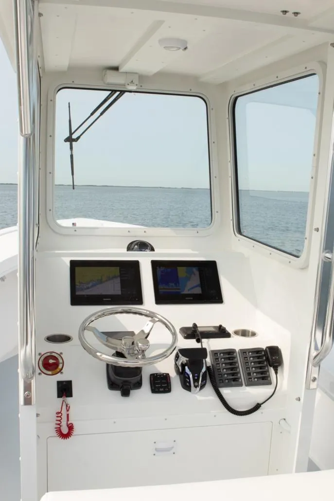 Slide: The Image of 2026 Steiger Craft 23 Chatham boat cockpit with navigation screens and steering wheel. - 4