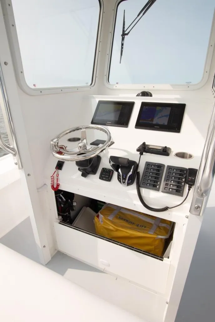 Slide: The Image of 2026 Steiger Craft 23 Chatham boat helm with navigation equipment and steering wheel. - 5