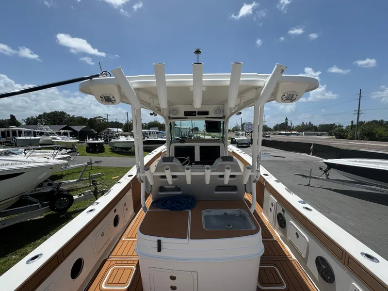 Slide: The Image of 2019 World Cat 3200 boat interior with fishing rod holders and sink, docked under blue sky. - 10