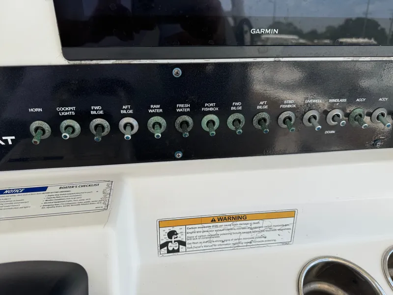 Slide: The Image of Control panel of a 2019 World Cat 3200 boat with various switches and warning labels. - 18