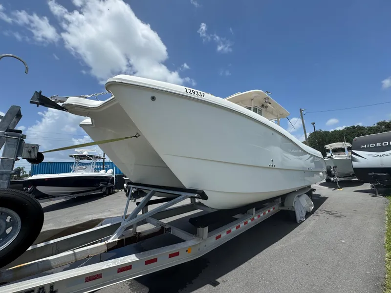 Slide: The Image of 2019 World Cat 3200 boat on trailer under clear blue sky. - 2