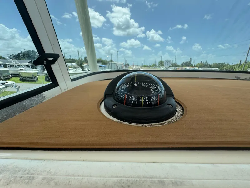 Slide: The Image of Compass on 2019 World Cat 3200 boat dashboard under clear blue sky. - 21