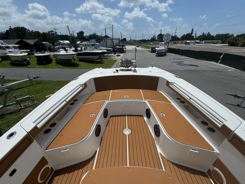 Slide: The Image of 2019 World Cat 3200 boat interior with tan deck, docked under a cloudy sky. - 23