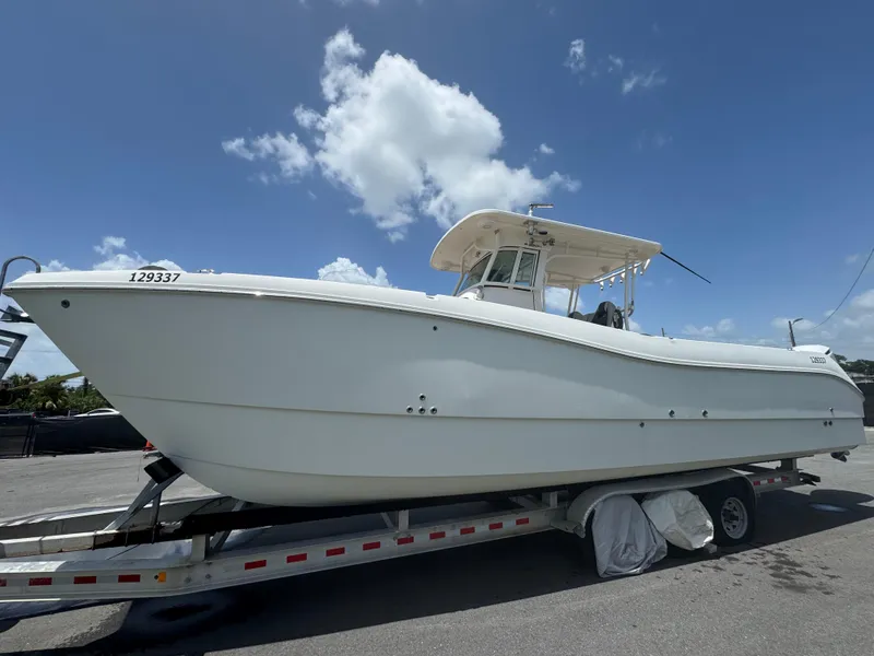 Slide: The Image of 2019 World Cat 3200 boat on trailer under clear blue sky. - 3
