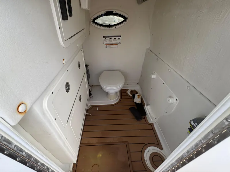 Slide: The Image of Interior of 2019 World Cat 3200 boat bathroom with toilet and wooden floor. - 44
