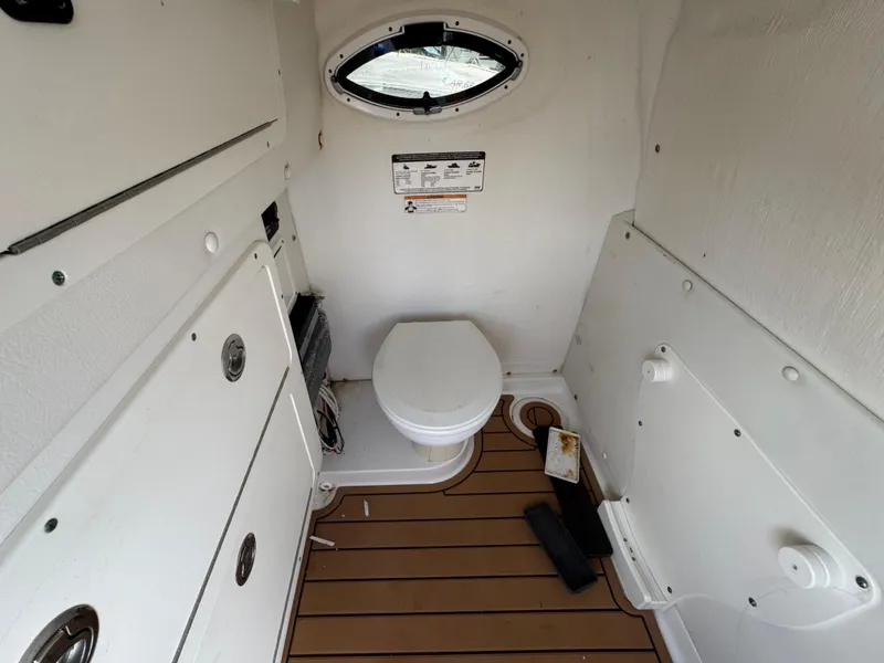 Slide: The Image of 2019 World Cat 3200 boat interior with toilet and porthole window. - 45