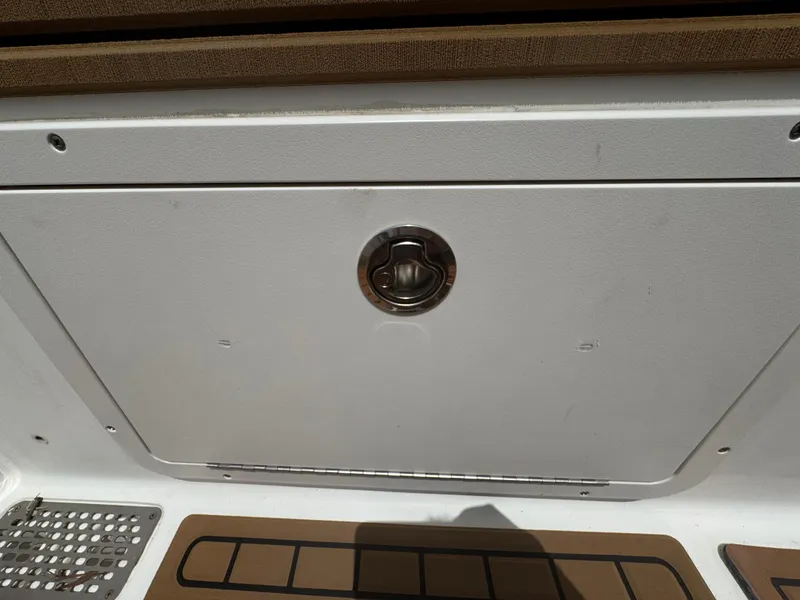 Slide: The Image of Compartment door on a 2019 World Cat 3200 boat, featuring a metal handle. - 49