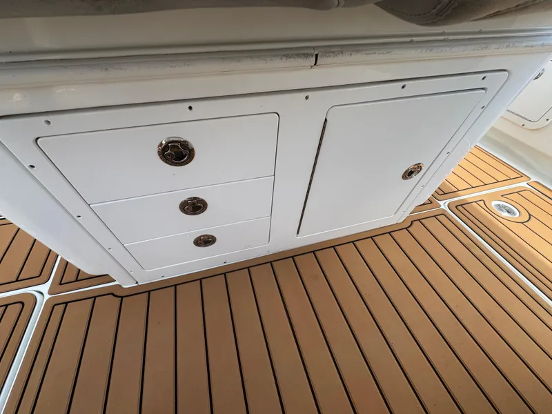 Slide: The Image of 2019 World Cat 3200 boat interior with white storage cabinets and teak flooring. - 62
