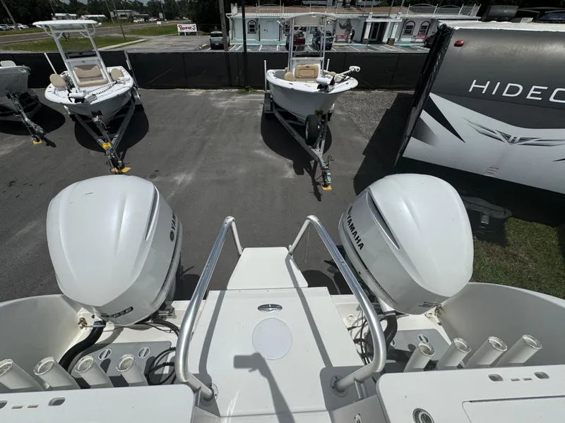 Slide: The Image of 2019 World Cat 3200 boat with Yamaha engines, parked near other boats and a trailer. - 77