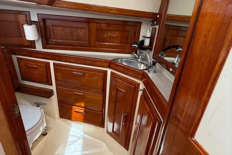 Slide: The Image of 1994 Pacific Seacraft Pilothouse 32 bathroom with wooden cabinetry and compact sink. - 10
