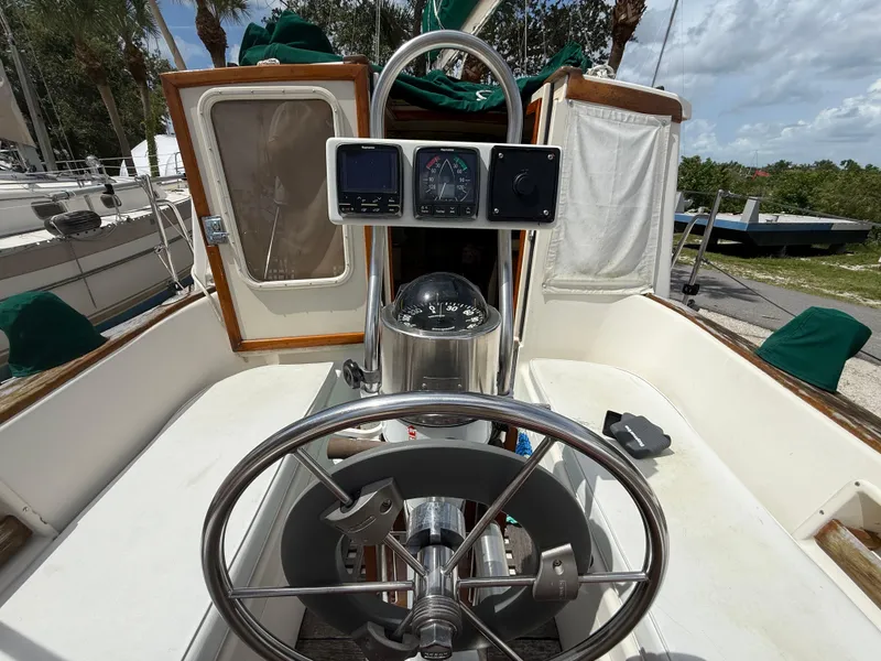 Slide: The Image of 1994 Pacific Seacraft Pilothouse 32 cockpit with steering wheel and navigation instruments. - 13
