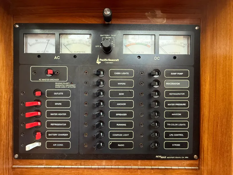 Slide: The Image of Electrical control panel of a 1994 Pacific Seacraft Pilothouse 32 yacht, featuring AC and DC switches. - 18