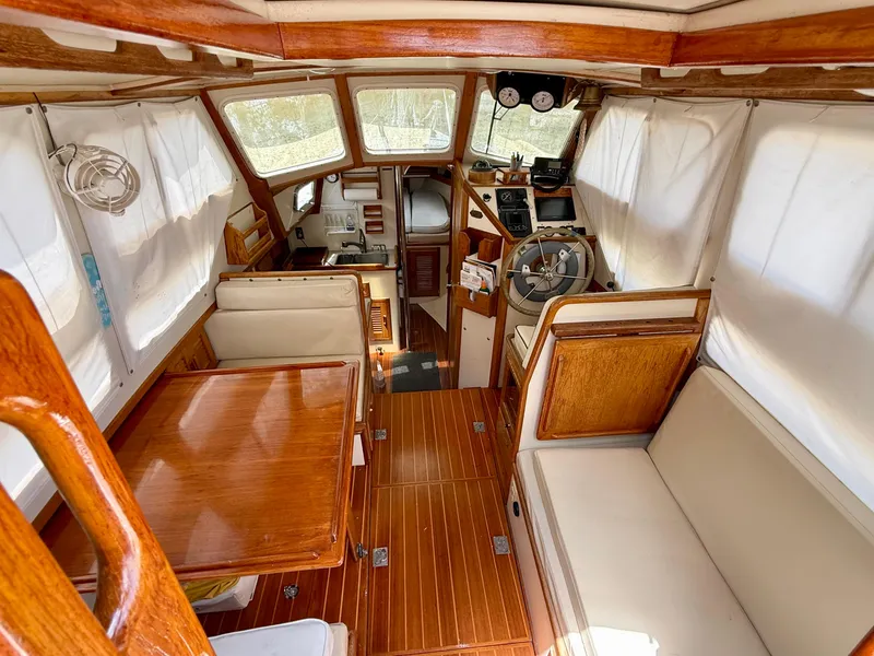 Slide: The Image of Interior of 1994 Pacific Seacraft Pilothouse 32, featuring wood finishes and seating area. - 2