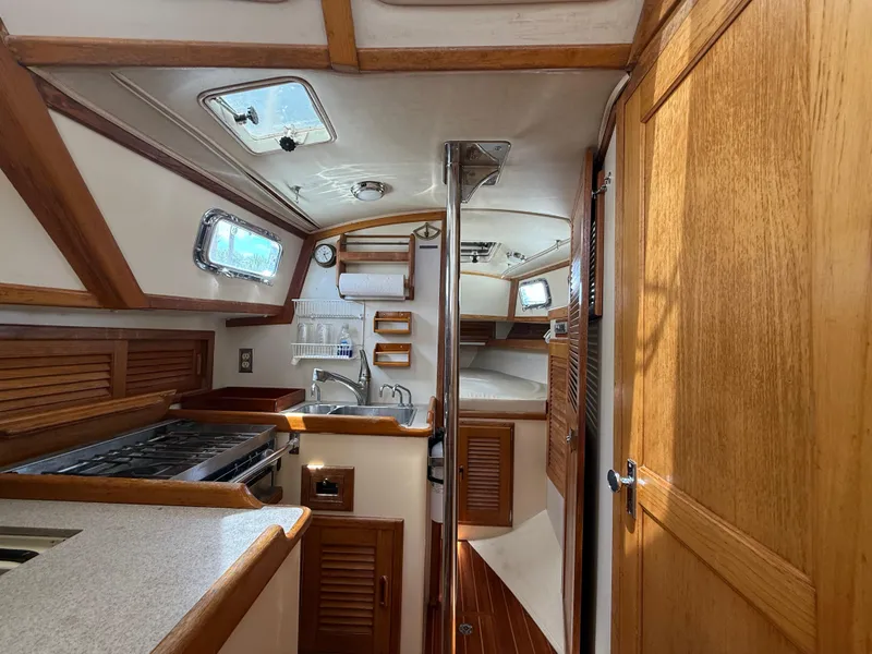 Slide: The Image of Interior of 1994 Pacific Seacraft Pilothouse 32, featuring kitchen and cozy cabin space. - 7