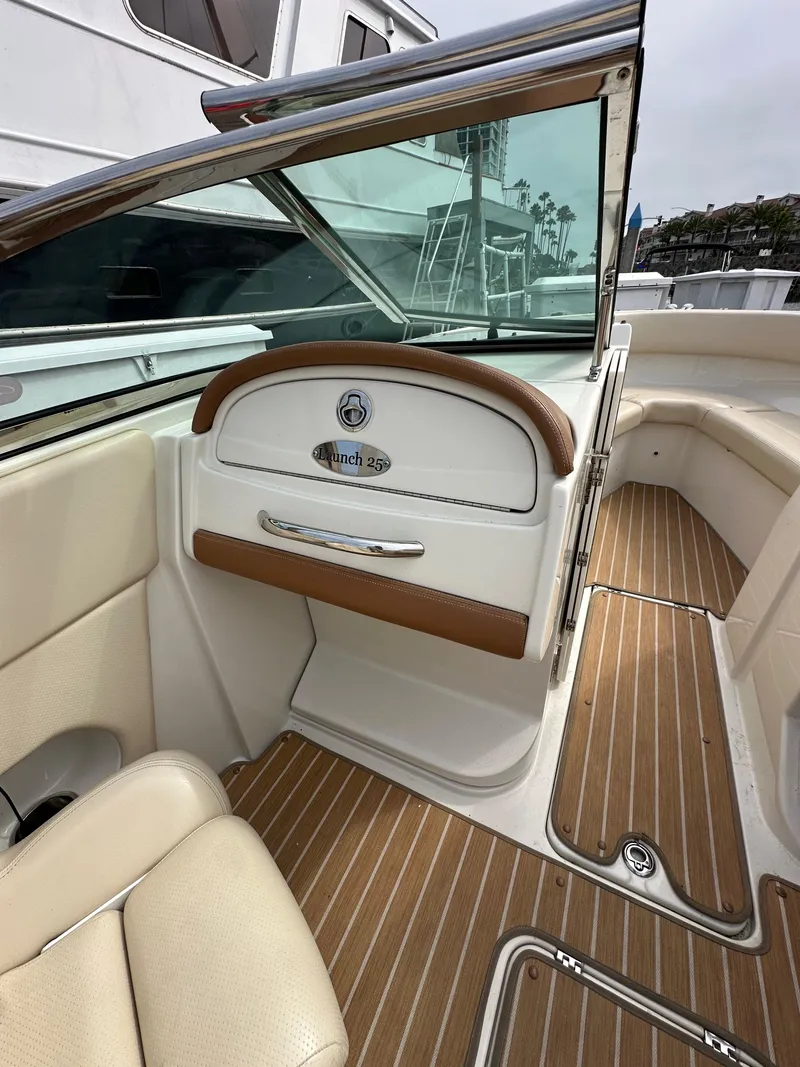 Slide: The Image of 2008 Chris-Craft Launch 25 interior with beige seating and wood flooring. - 10