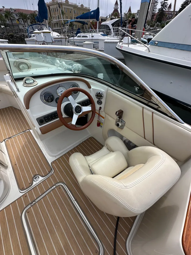 Slide: The Image of 2008 Chris-Craft Launch 25 boat interior with steering wheel and dashboard, docked at marina. - 13