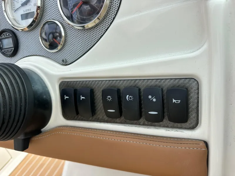 Slide: The Image of Dashboard controls of a 2008 Chris-Craft Launch 25 boat with switches and gauges. - 16