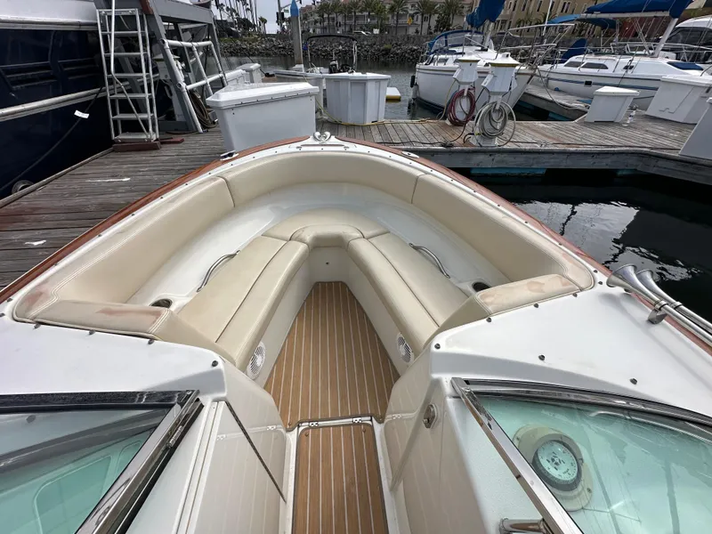 Slide: The Image of 2008 Chris-Craft Launch 25 boat with beige seating and wooden deck at a marina. - 19