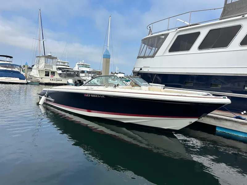 Slide: The Image of 2008 Chris-Craft Launch 25 boat docked in a marina, surrounded by other vessels. - 2