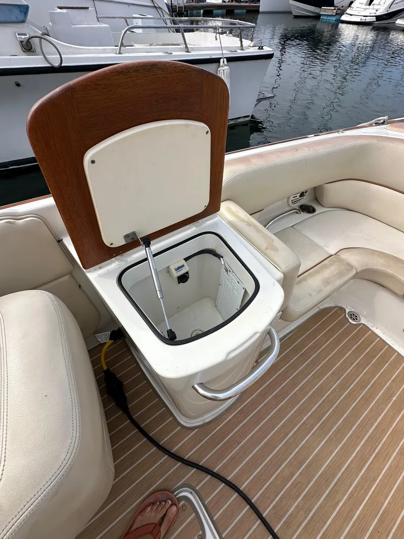 Slide: The Image of 2008 Chris-Craft Launch 25 boat interior with open storage compartment, docked at marina. - 26
