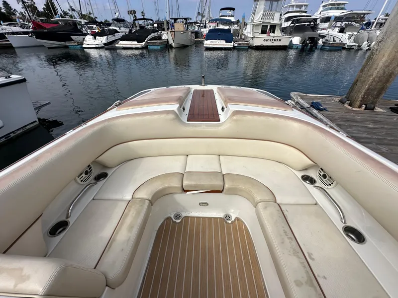 Slide: The Image of 2008 Chris-Craft Launch 25 boat interior with beige seating at a marina. - 28