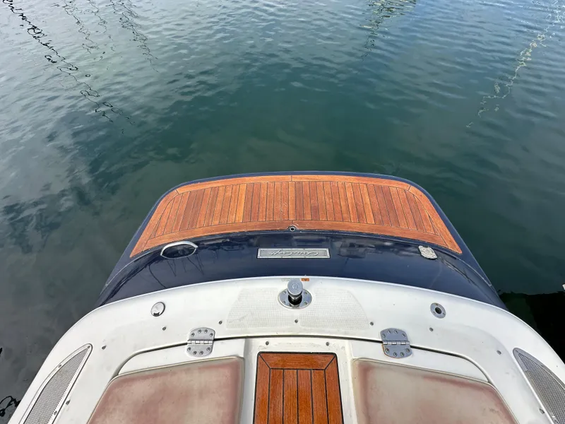Slide: The Image of 2008 Chris-Craft Launch 25 boat with wooden deck, docked on calm water. - 30