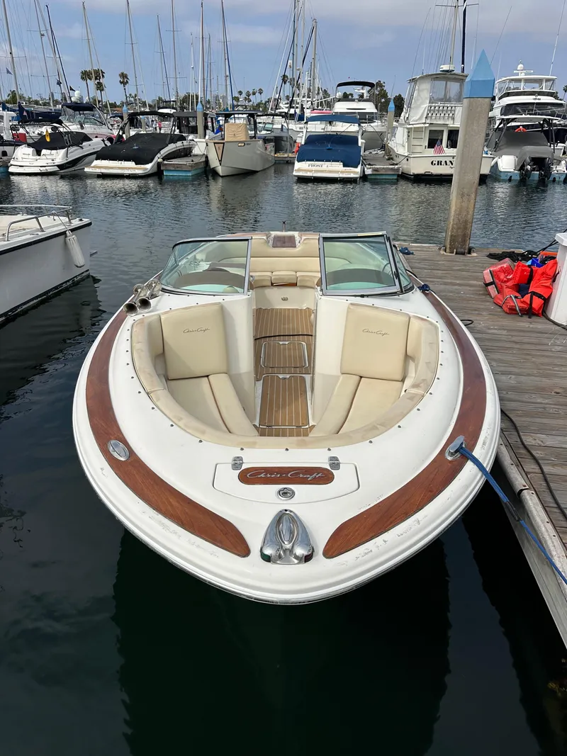 Slide: The Image of 2008 Chris-Craft Launch 25 boat docked in a marina, surrounded by other vessels. - 4