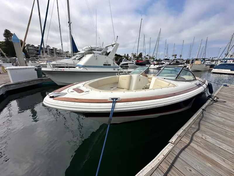 Slide: The Image of 2008 Chris-Craft Launch 25 boat docked in a marina, surrounded by other vessels. - 5