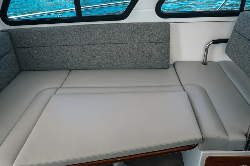 Slide: The Image of 2027 Lindell 41' yacht interior with gray cushioned seating and ocean view. - 32