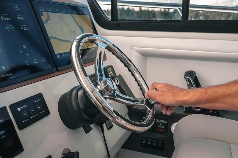Slide: The Image of Steering wheel and controls of a 2027 Lindell 41' boat with navigation screens. - 35