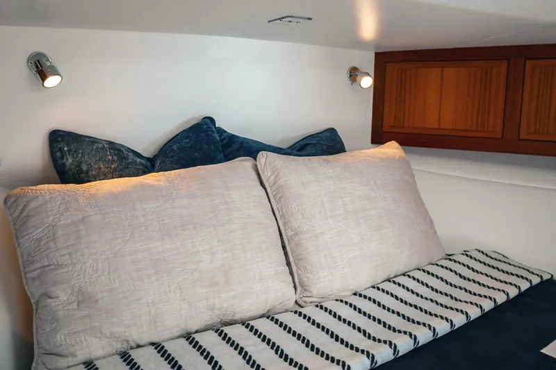Slide: The Image of Cozy cabin interior of 2027 Lindell 41' yacht with plush pillows and striped bedding. - 41