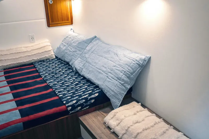 Slide: The Image of Cozy cabin interior of 2027 Lindell 41' boat with plush bedding and soft lighting. - 49