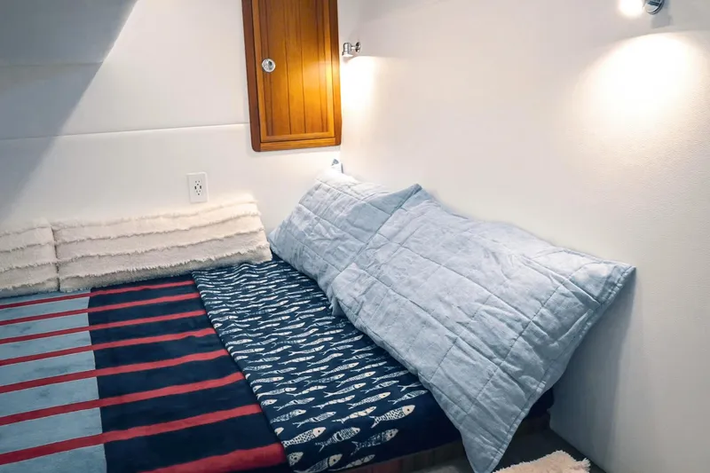 Slide: The Image of Cozy cabin interior of 2027 Lindell 41' boat with striped bedding and soft lighting. - 50