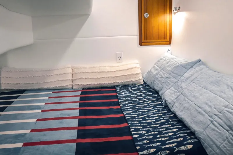 Slide: The Image of Cozy cabin interior of 2027 Lindell 41' boat with striped bedding and soft lighting. - 51