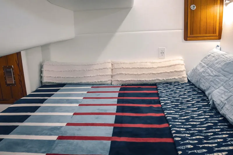 Slide: The Image of Cozy cabin interior of a 2027 Lindell 41' boat with striped bedding. - 52