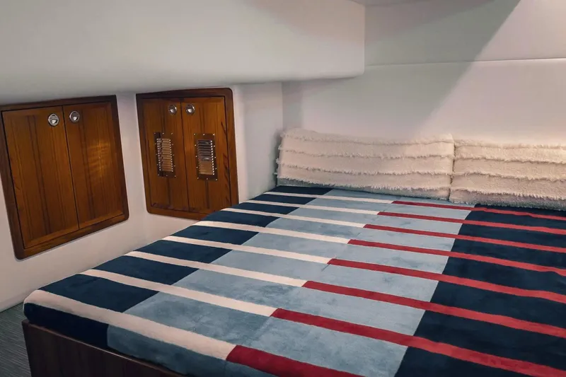 Slide: The Image of Interior of 2027 Lindell 41' yacht with striped bedding and wooden cabinets. - 53