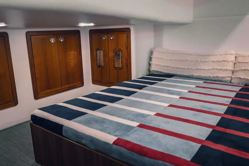 Slide: The Image of Luxurious cabin interior of 2027 Lindell 41' yacht with striped bedding and wooden cabinets. - 54